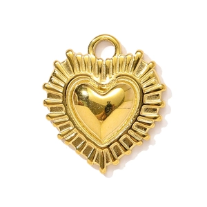 Détail d'un pendentif cœur doré avec motif rayon de soleil et boucle de suspension