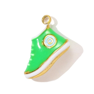 Detailed macro view of green enamel sneaker pendant with gold metal edges for DIY jewelry