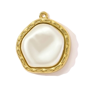 Dettaglio di un ciondolo vintage dorato con inserto di perla bianca irregolare