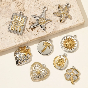 Mélange de pendentifs en acier or et argent incluant palmier et motifs mauvais œil