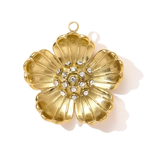 Detailed view of a gold flower pendant with radial texture and sparkling rhinestones