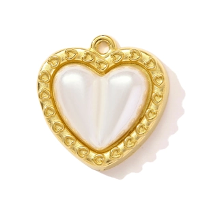 Macro del ciondolo a cuore in perla con cornice in metallo dorato e piccoli cuori incisi