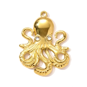 Macro detail of a golden octopus pendant with sparkling rhinestone eyes on white back