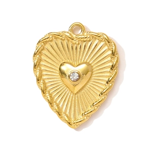 Detailed macro view of gold heart pendant with sunburst texture and sparkling crystal