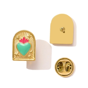 Detailed view of arch-shaped enamel brooch with green heart and pink flame design