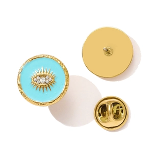 Detailed macro view of gold evil eye enamel brooch with turquoise inlay and rhinestones