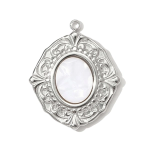 Macro view of vintage silver steel pendant with Victorian relief and white pearl inlay