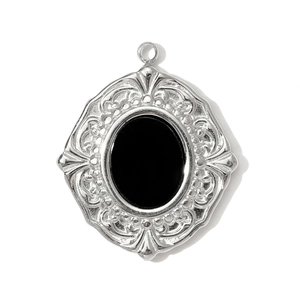 Detailed view of a vintage silver pendant with ornate carvings and black stone inlay
