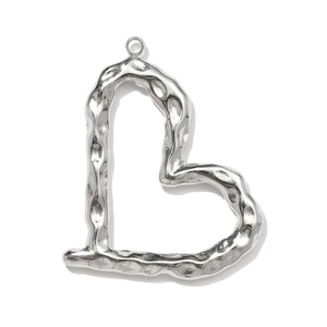 Macro detail of silver heart pendant featuring a unique hammered metal texture surface