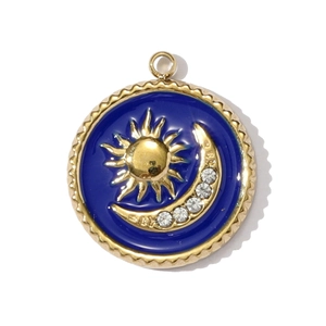 Detalle de colgante de esmalte azul con sol, luna y cristales brillantes en dorado