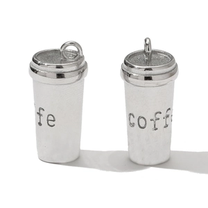 Macro shot of silver coffee cup charms with coffee engraving for DIY jewelry making