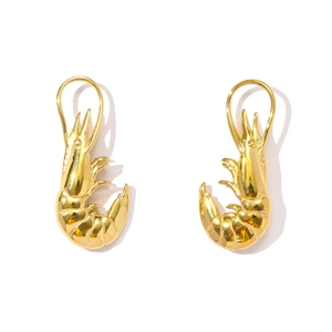 Detail of 3D prawn earrings in shiny gold finish with realistic crustacean textures