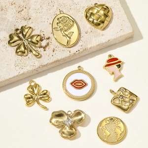 Set of 9 gold stainless steel charms including clover, heart, and floral designs for DIY jewelry