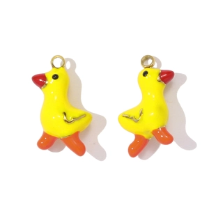 Close-up of yellow duckling charms with golden details and vibrant enamel finish