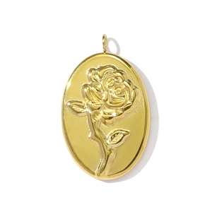 Detailed close-up of oval gold pendant featuring an embossed rose flower design