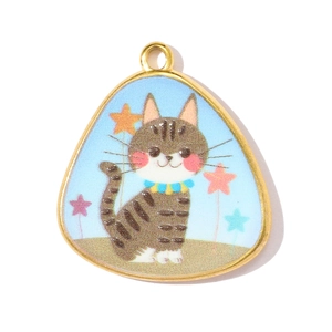 Detail of a triangle pendant featuring a cartoon striped cat and stars on light blue enamel