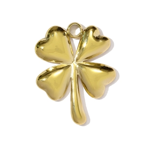 Close-up of a polished gold clover pendant with four heart-shaped petals and top ring