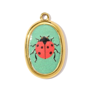 Detailed close-up of a gold oval ladybug pendant with a vintage French design