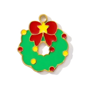 Details eines Weihnachts-Anhängers mit grünem Emaille-Kranz, roter Schleife und Gold