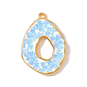 Detailed view of sun flower pendant with blue vine patterns on white enamel and gold frame
