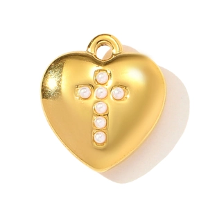 Close-up of a golden heart pendant featuring a cross set with white pearls