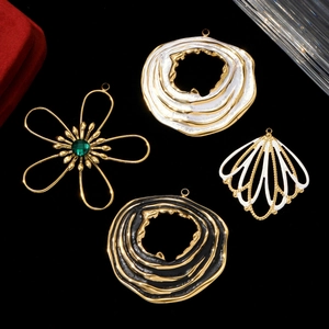 Elegant gold and enamel floral pendants and earrings on a black textured background