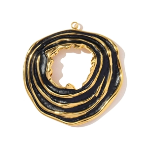 Macro view of gold and black wavy enamel texture on large hollow round pendant
