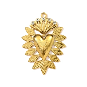 Detail of golden heart pendant with starburst engraving and sparkling crystal accents