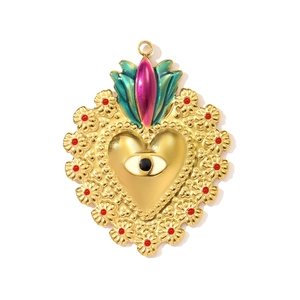 Detail of a golden heart evil eye pendant with intricate engravings and colorful accents