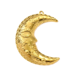 Macro shot of gold crescent moon pendant featuring a detailed sleeping face and flowers