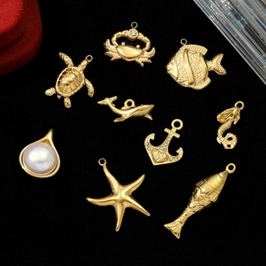 Golden ocean theme stainless steel pendants with pearls and rhinestones on black background