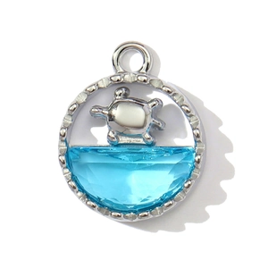 Detailed macro view of a silver turtle pendant with faceted blue crystal and bead texture