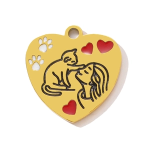 Detail of golden heart pendant with girl, cat pattern and red enamel hearts