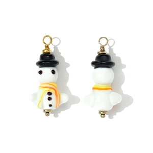 Macro view of handmade glass snowman pendant with striped scarf and golden hook