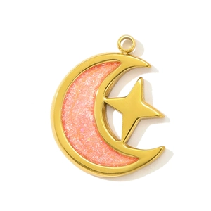 Dettaglio di un ciondolo in acciaio inossidabile dorato a forma di luna e stella con glitter