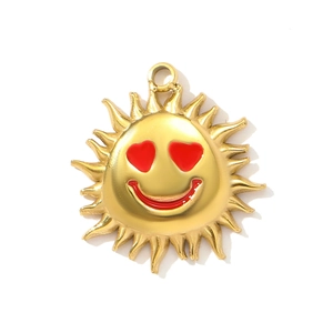 Detail of a golden sun pendant with red heart eyes and a smiling face for jewelry DIY