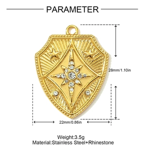 Detailed view of a gold shield pendant with rhinestones and product size 28x22mm