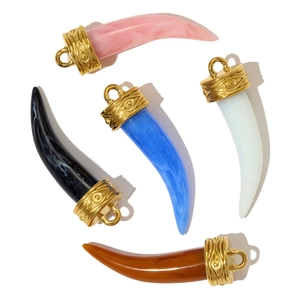 Detail of horn pendants with marble texture and gold engraved eye symbols