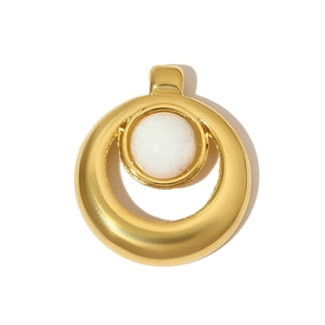 Détail d'un pendentif vintage en acier inoxydable avec pierre blanche et finition dorée