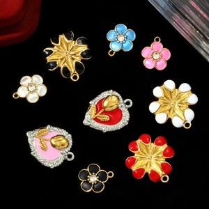 Detailed view of DIY enamel heart and daisy flower charms for jewelry making