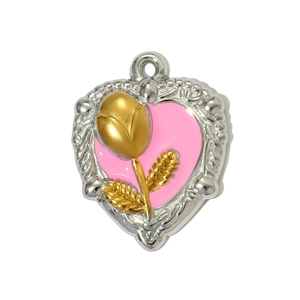 Detailed macro view of heart-shaped pendant with pink enamel and gold floral accents