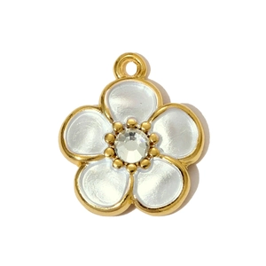 Macro shot of white enamel daisy pendant with gold frame and crystal center