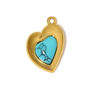 Détail d'un pendentif coeur en or avec pierre turquoise et relief de petite croix