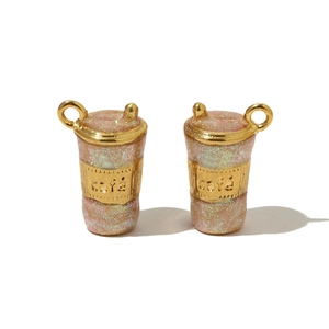 Detailed pair of golden coffee cup pendants with pink glitter and café engraving