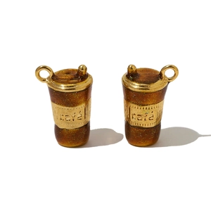 Macro detail of 3D coffee cup pendant in gold and amber resin with café engraving