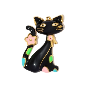 Detail van een zwarte emaille kattenhanger met gouden rand en roze bloemaccenten