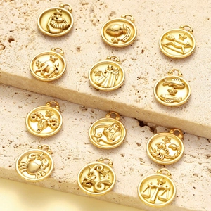 Matte gold stainless steel zodiac pendant set with 12 signs on stone display pedestal