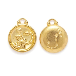 Detailed macro view of golden Scorpio zodiac charms with embossed scorpion and star map patterns