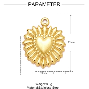 Macro view of a 22mm golden stainless steel heart pendant with sunburst texture details