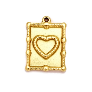 Detail of a golden rectangular pendant with a raised heart and bamboo-textured frame